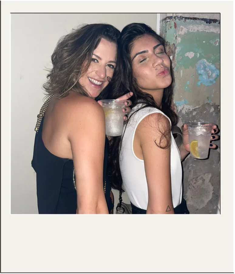 Bianca e Bruna brindando e sorrindo em uma festa