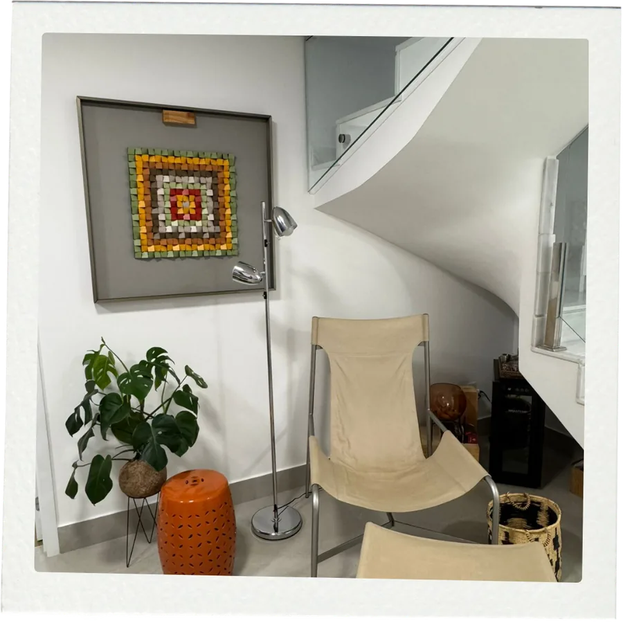 Sala de estar com quadro, planta e poltrona
