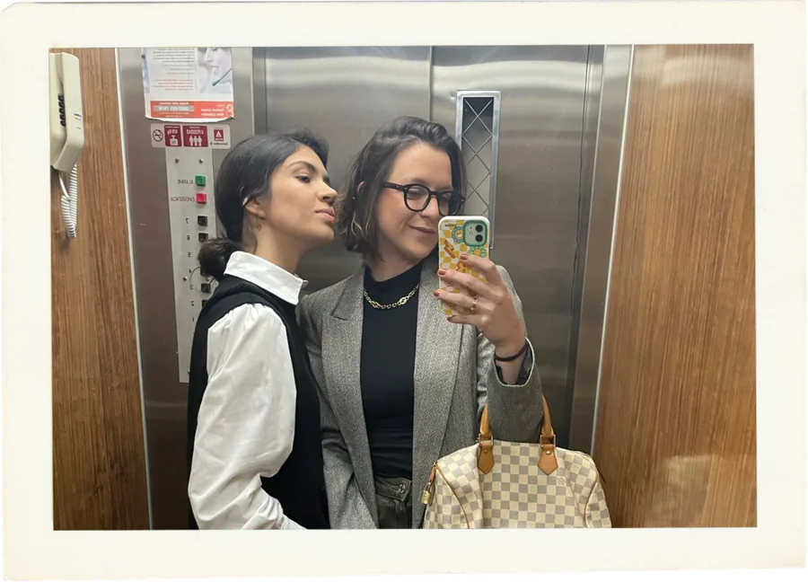 Bianca e Bruna se abraçando em frente ao espelho do elevador