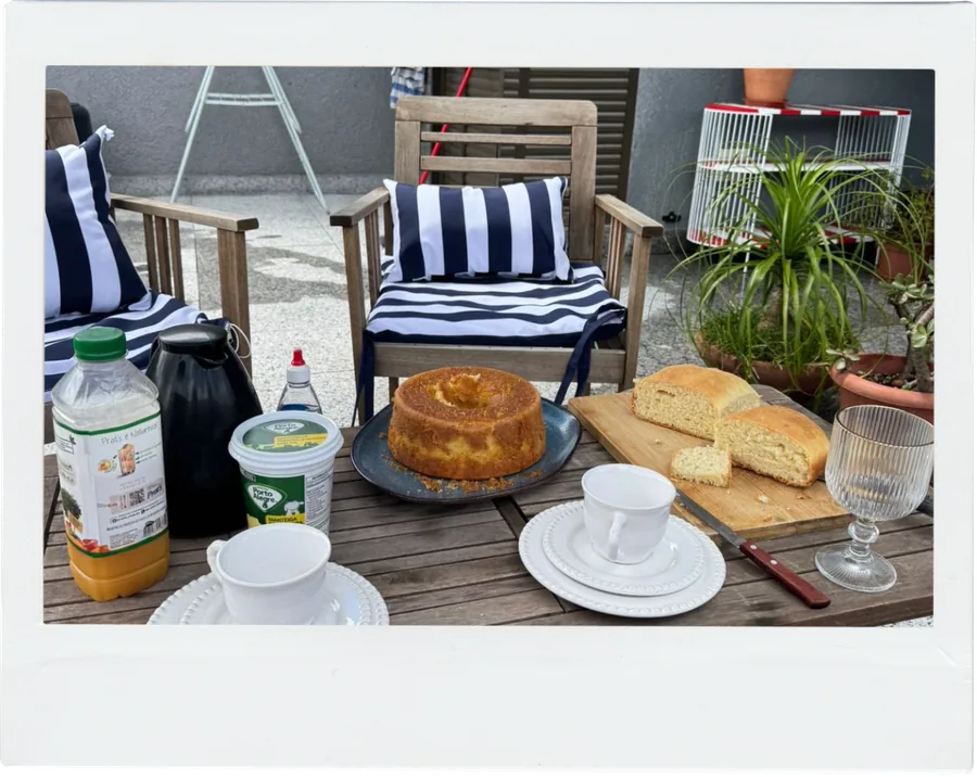 Mesa de café da manhã ao ar livre, com bolo e pão de queijo