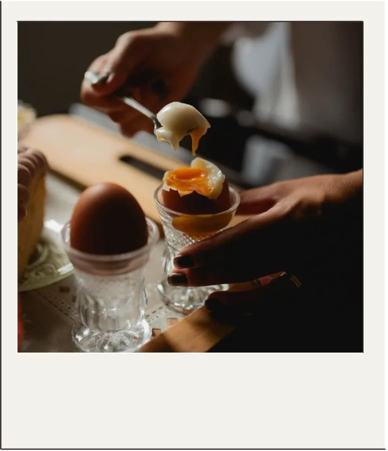 Foto de um café da manhã com ovo cozido sendo preparado à mesa